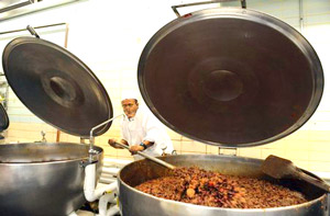 アナポリス海軍兵学校の厨房にてパドルで煮物を混ぜるおじさん